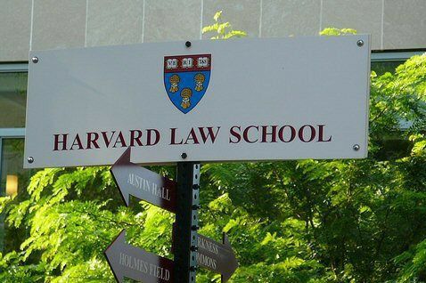 a sign for harvard law school with trees in the background