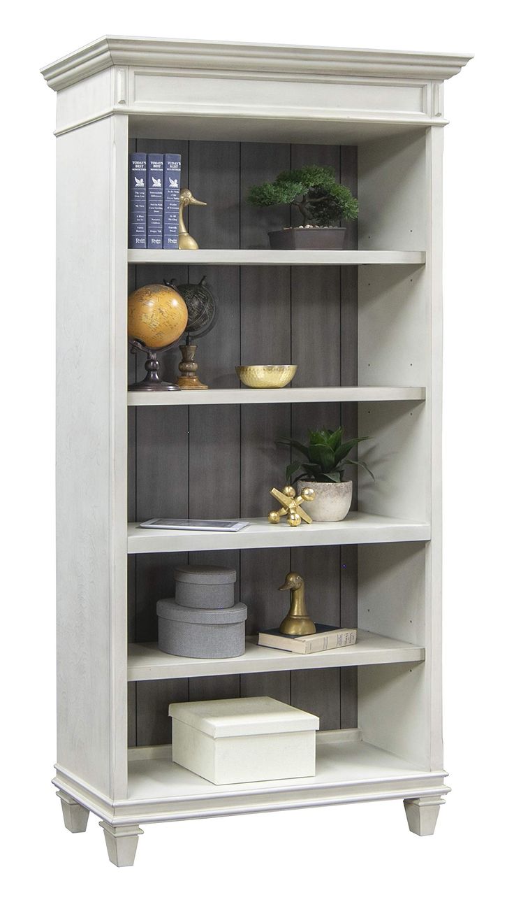 a white bookcase with plants and other items on it