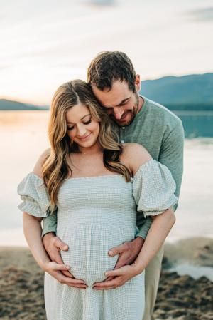 a man and woman standing next to each other while holding their pregnant baby bump on the belly