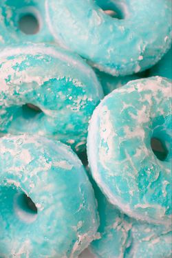 there are many blue donuts with white frosting on them