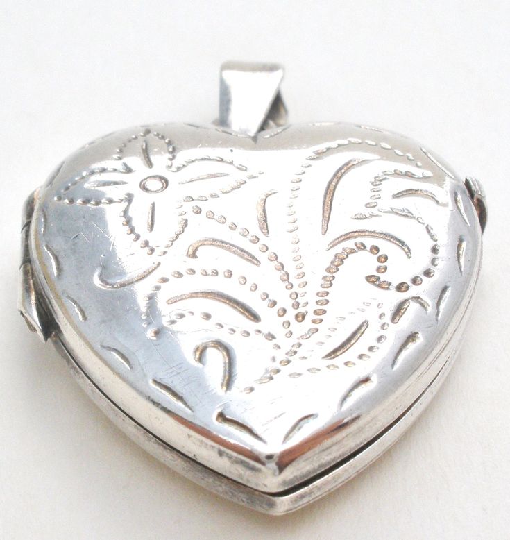 Italian Jewelry - This is a sterling silver heart locket picture pendant with a floral etch design. It is hallmarked 925 Italy, maker's mark with M in square. The pendant measures 1.25" by 1", weighs 6.4 grams, opens and closes properly, still has plastic inserts to cover photos. There are light surface scratches on the back. Silver Heart Locket Necklace Collectible, Silver Heart Pendant Locket Necklace, Antique Silver Heart Locket Necklace, Victorian Silver Heart Pendant Locket Necklace, Antique Silver Locket Necklace For Valentine's Day, Silver Heart Pendant Locket Necklace With Hallmark, Vintage Silver Locket Necklace For Valentine’s Day, Victorian Silver Locket Necklace With Heart Charm, Heart Shaped Hallmarked Silver Locket Necklace