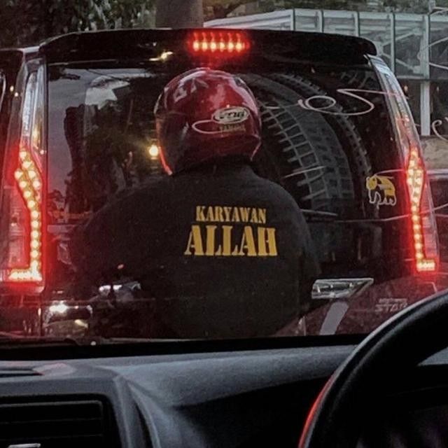 the rear view mirror of a car with a person wearing a black jacket on it