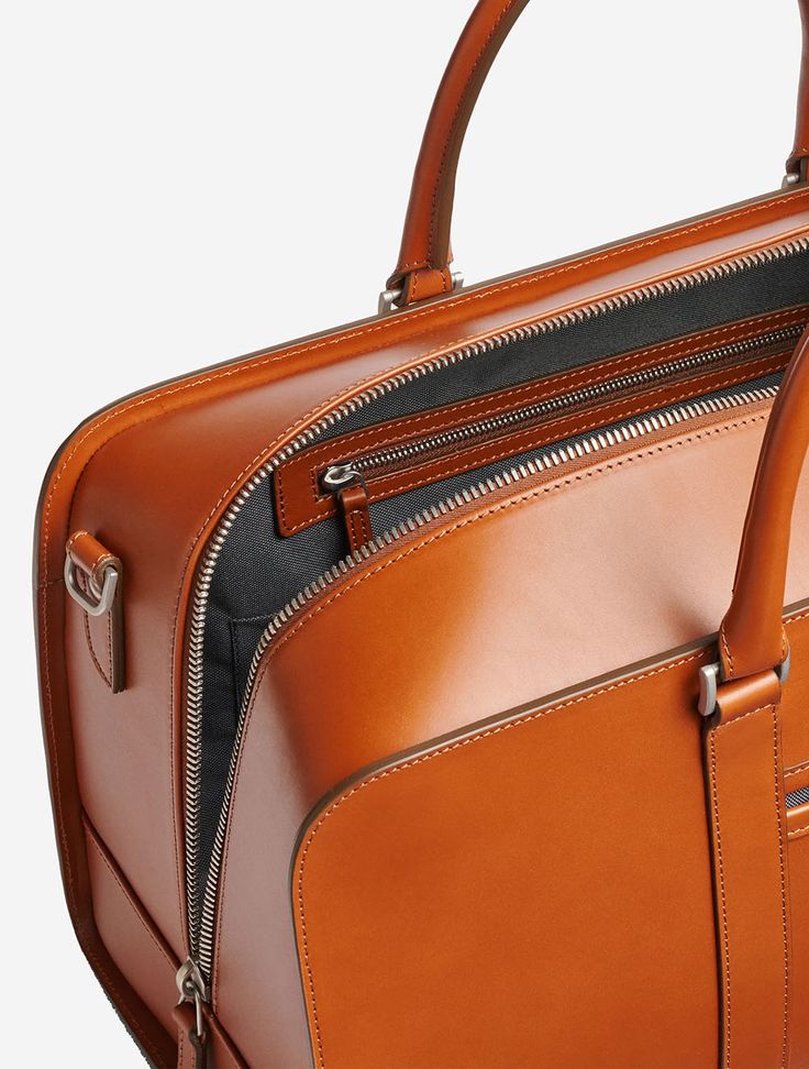 An all-leather weekend bag carrying the getaway essentials in style. Suitable for up to 48 hours on the move. The upright construction ensures the elegant shape remains intact over time. Unlike other weekend bags, Palissy Weekend retains its sturdy, upright shape for many a journey to come. Our vachetta is vegetable-tanned using centuries-old techniques, giving it a luxuriously smooth and natural finish that's sure to catch the eye. The Smart Holder allows Palissy Weekend to clip onto the trolle Luxury Cognac Weekender Bag For Everyday, Formal Rectangular Weekender Bag With Leather Lining, Timeless Brown Briefcase For Travel, Classic Cognac Travel Tote Bag, Classic Cognac Tote Travel Bag, Cognac Travel Bag With Leather Handles For Business, Business Weekender Bag In Cognac With Luggage Sleeve, Business Weekender Bag With Luggage Sleeve In Cognac, Luxury Tote-style Luggage With Zipper Closure