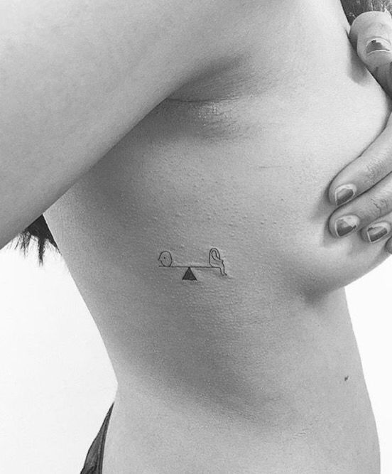 a black and white photo of a woman's stomach with an arrow tattoo on it