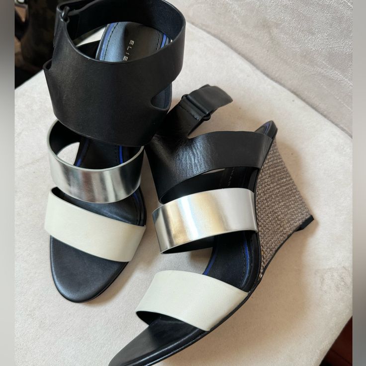 New. Size 38.5 (Us 8). Black, Silver & Ivory. Adjustable Ankle Strap. 3” Heels. Leather Uppers, Footbed & Outsole. New But One Small Scratch On Middle Band. See Last Pic. Silver Leather Wedge Sandals For Party, Silver Wedge Sandals With Heel Strap For Spring, Chic Silver Sandals With Removable Insole, Spring Silver Ankle Strap Wedge Sandals, Silver Ankle Strap Wedge Sandals For Spring, Silver Open Heel Wedge Sandals For Spring, Chic Silver High Heel Wedge Sandals, Chic Silver Wedge Sandals With Round Toe, Elie Tahari