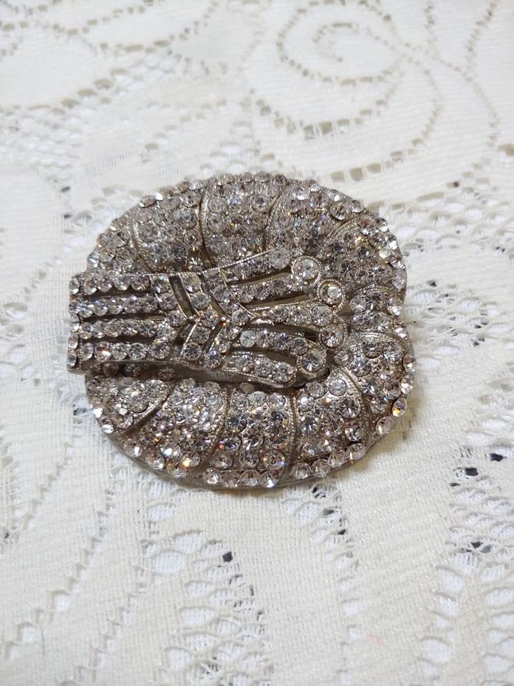 This piece is an unaltered 1920s art deco rhinestone brooch. The piece is done in all silver tone pot metal, loaded with vintage rhinestones. Perfect for the gatsby wedding or themed event! Please see all pictures on this piece for a better description and sizing. (9) Silver Art Deco Brooches For Wedding, Silver Art Deco Wedding Brooch, Silver Art Deco Wedding Brooches, Silver Gatsby Jewelry For Vintage Events, Silver Rhinestone Brooch For Vintage Events, Silver Rhinestone Brooches For Vintage Events, Vintage Sparkling Wedding Brooches, Flapper Hair, Gatsby Wedding