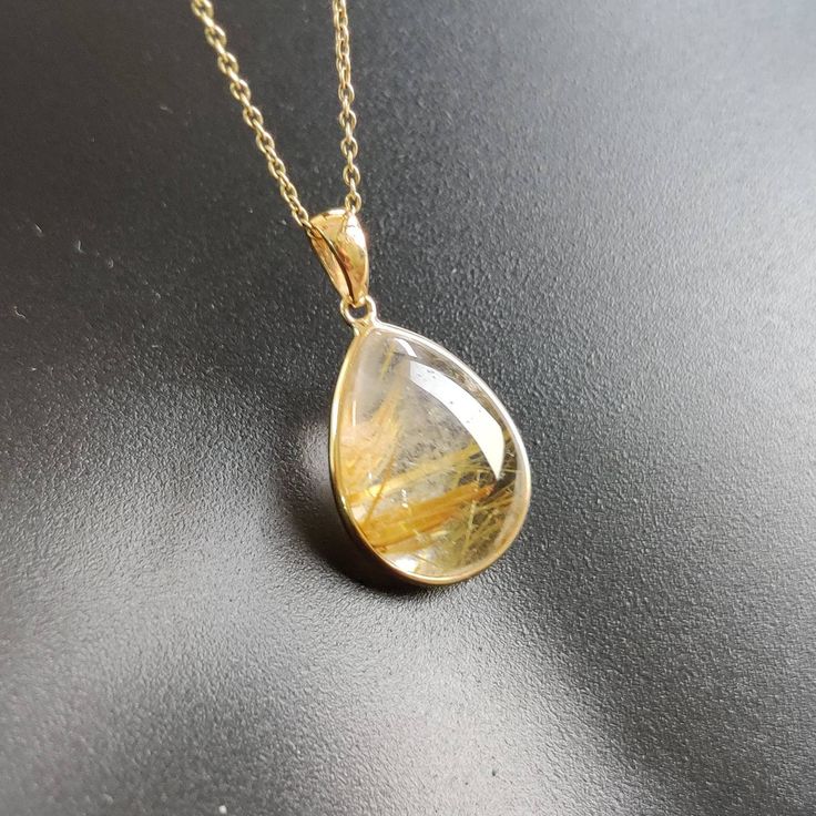 ITEM DESCRIPTION: >>The pendant is made from Solid 14K Yellow Gold. Gemstone used is absolutely natural and ethically sourced. >>Natural Golden Rutile in cabochon cut and pear shape with bezel setting is studded on it with utmost precision. >>This is a minimalist design and is absolutely hassle-free and everyday jewelry. Gem: Golden Rutile Gem size: 12x17 mm Gem weight: 10.36 carats Gold purity: 14K (58.33% approx.) Gold weight: 0.69 grams Gross weight: 2.72 grams The Gold purity is guaranteed a 14k Gold Briolette Gemstones For Gift, Yellow Gold Gemstones For Gift, Fine Jewelry Style, Fine Jewelry In Yellow Gold With Natural Inclusions, Teardrop 14k Gold Jewelry With Natural Stones, 14k Gold Teardrop Jewelry With Natural Stones, 14k Yellow Gold Gemstones For Gift, Hallmarked Yellow Gold Gemstones For Gift, Gold Pendant Gemstones As A Gift, Gold Pendant Gemstones For Gift