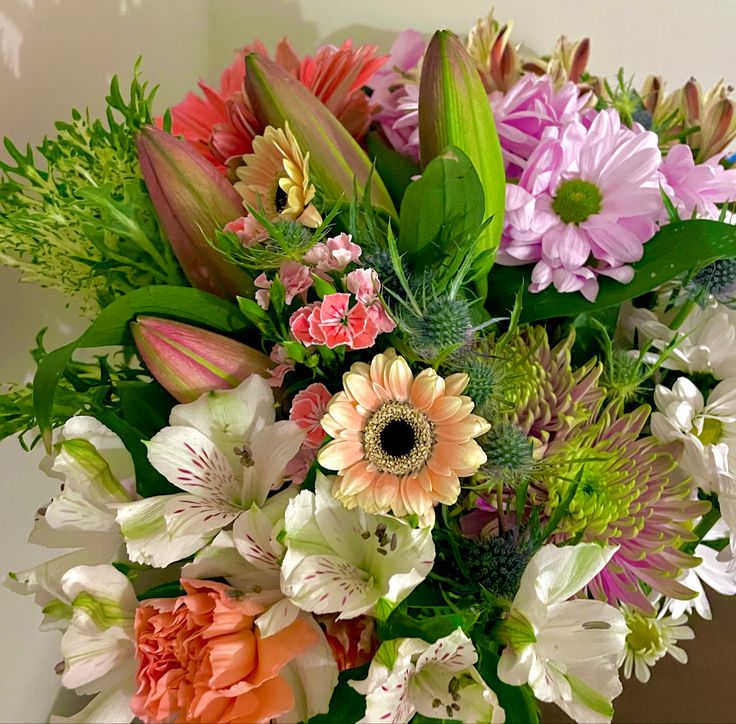 a vase filled with lots of different colored flowers