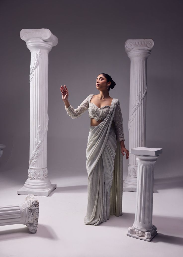 An exquisit Italian imported fabric being the key highlight of this ensemble which is sure to never go out of trend. An artistic symphony of fine aari embroidery adorns the blouse with full sleeves. It has 3D katdana loops, this unreal detailing enhance the ethreal look of the outfit. Colour: Glacier Gray Material: Italian - Saree, Organza- Blouse No of components: 2 Surface Ornamentation: Hand Embroidery Care Instructions: Dry Clean Shipping Time: 3-4 weeks Embroidered Pre-draped Saree With Long Sleeves For Reception, Hand Embellished Georgette Sets With Long Sleeves, Hand Embellished Long Sleeve Georgette Sets, Fitted Sets With Traditional Drape In Elegant Style, Hand Embellished Elegant Silk Choli, Elegant Georgette Blouse With Intricate Embroidery, Elegant Pre-draped Saree With Zari Work, Elegant Formal Pre-draped Saree With Resham Embroidery, Elegant Hand Embellished Choli With Traditional Drape