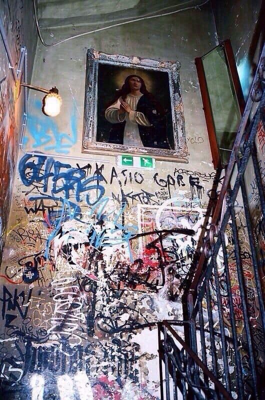 a stairwell with graffiti and a painting on the wall