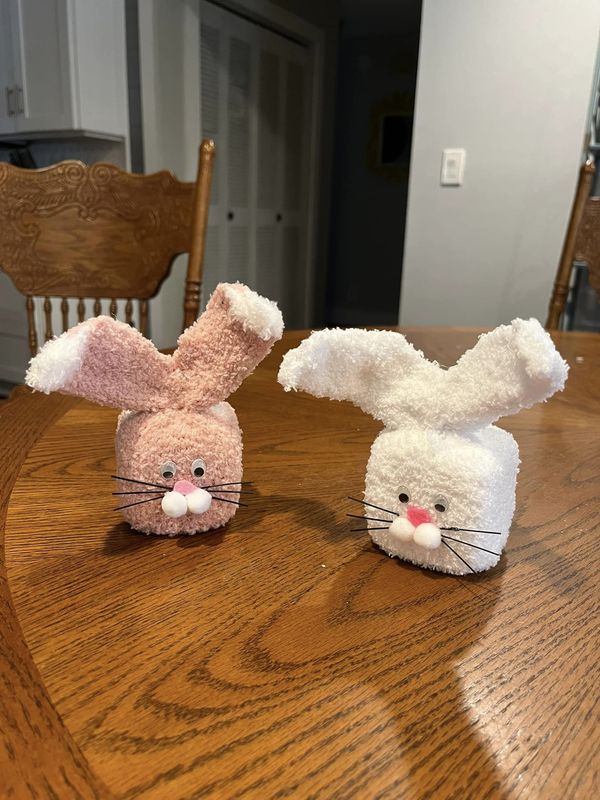 two stuffed animals sitting on top of a wooden table