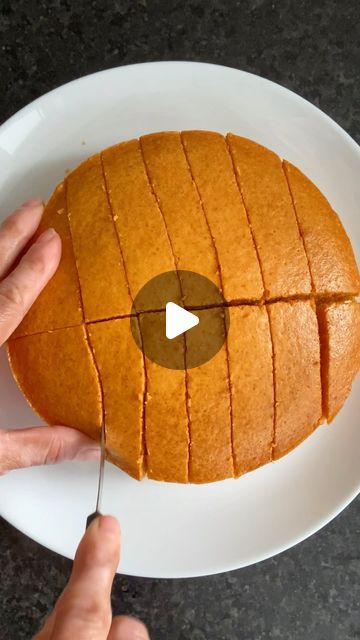 a person cutting into a piece of bread on a plate with a knife and fork