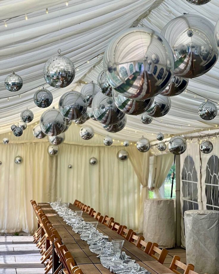 a long table is set up with silver plates and wine glasses in front of it