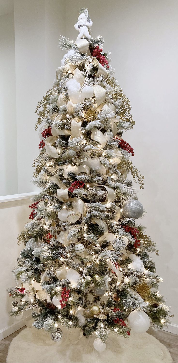 a white christmas tree with red and silver ornaments