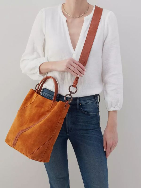 The perfect tote for fall. Elegant Cognac Bucket Bag For On-the-go, Leather Bucket Bag For On-the-go Use In Fall, Cognac Bucket Bag With Leather Handles, Modern Bucket Bag For On-the-go, Fall Season, Cognac Top Handle Satchel For Shopping, Fall Leather Hobo Bag With Detachable Handle, Leather Hobo Bag With Detachable Handle For Fall, Modern Top Handle Bucket Bag For Fall, Chic Rectangular Bucket Bag For Fall