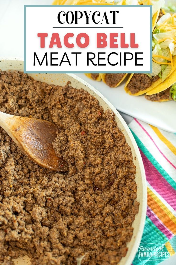 taco bell meat recipe in a white bowl with a wooden spoon next to it