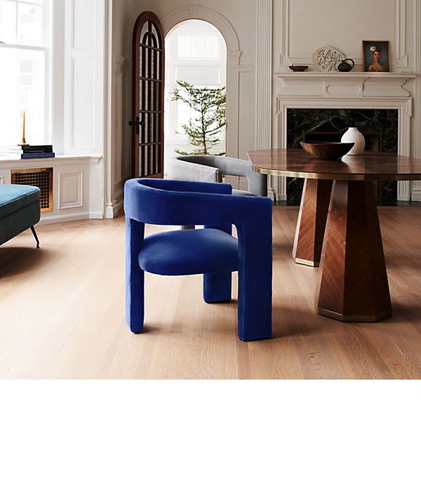 a blue chair sitting in front of a table next to a fire place and fireplace