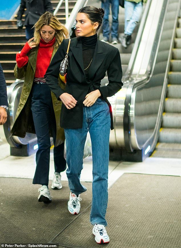 two women are walking down an escalator