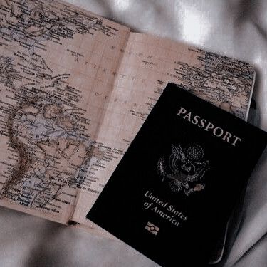 an open passport sitting on top of a bed