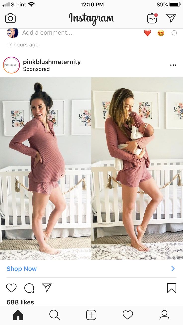 two women in matching outfits standing next to a baby crib and smiling at the camera