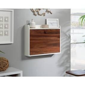 a white and wood cabinet hanging on the wall next to a plant in a vase