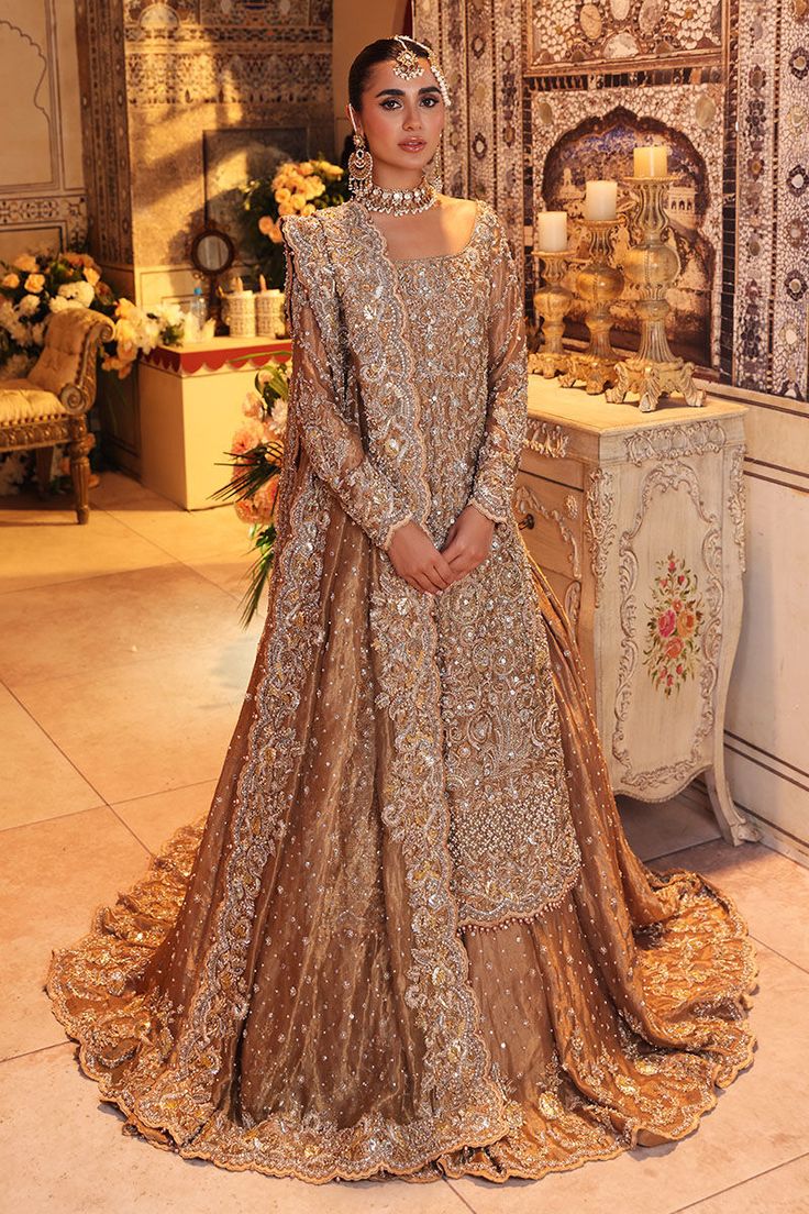 a woman standing in front of an archway wearing a long dress with intricate patterns on it