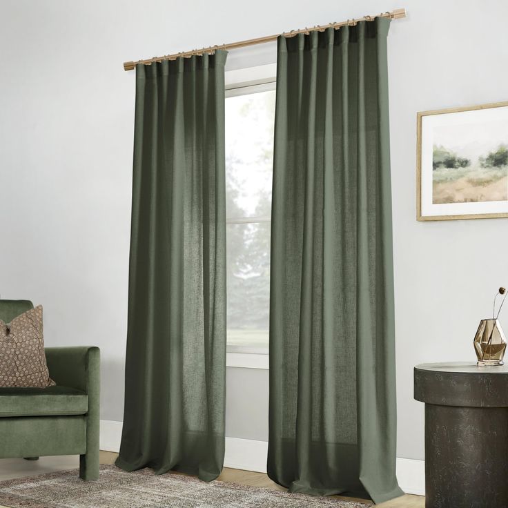 a living room with green curtains and a chair