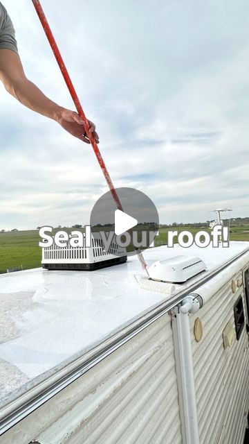 a man is cleaning the roof of a trailer with a broom and water hoses