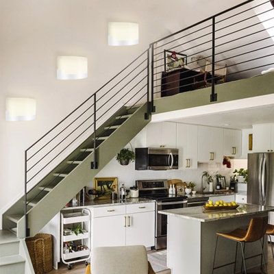 a kitchen and living room with stairs leading up to the second floor, as well as a dining area