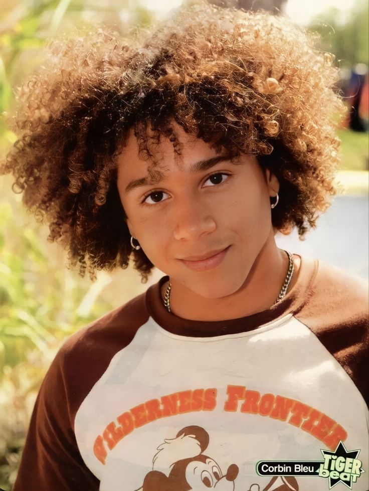 a young boy with an afro wearing a mickey mouse shirt