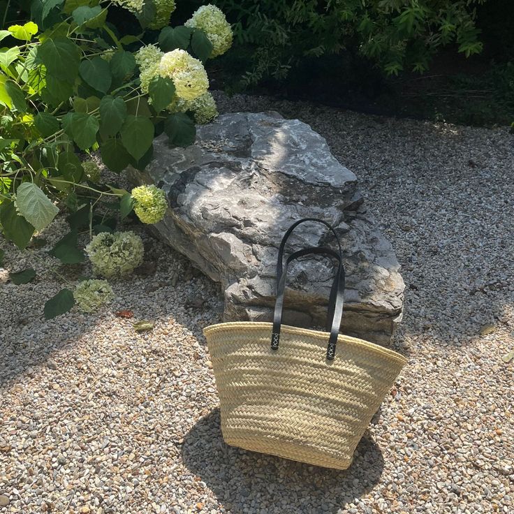 The Dahlia Tote Basket is a modern take on the French market tote featuring black leather shoulder straps. Use it as a beach bag, a pool tote, or a spacious picnic basket. When you're home, it makes for an attractive storage option hanging up or in a corner. Keep your basket in your car or display it on a hook near your front door so you're never without this useful tote basket. The basket is super lightweight with a sturdy flexible weave made of date palm leaves with a flat bottom to keep the b Everyday Summer Bucket Bag With Rolled Handles, Summer Everyday Bucket Bag With Rolled Handles, Chic Natural Bucket Bag With Rolled Handles, Travel Bucket Bag With Rolled Handles, Modern Bucket Straw Bag With Braided Handles, Modern Straw Bag For Vacation, Spring Bucket Bag With Rolled Handles, Spring Bucket Bag With Rolled Handles For Everyday Use, Spring Everyday Bucket Bag With Rolled Handles