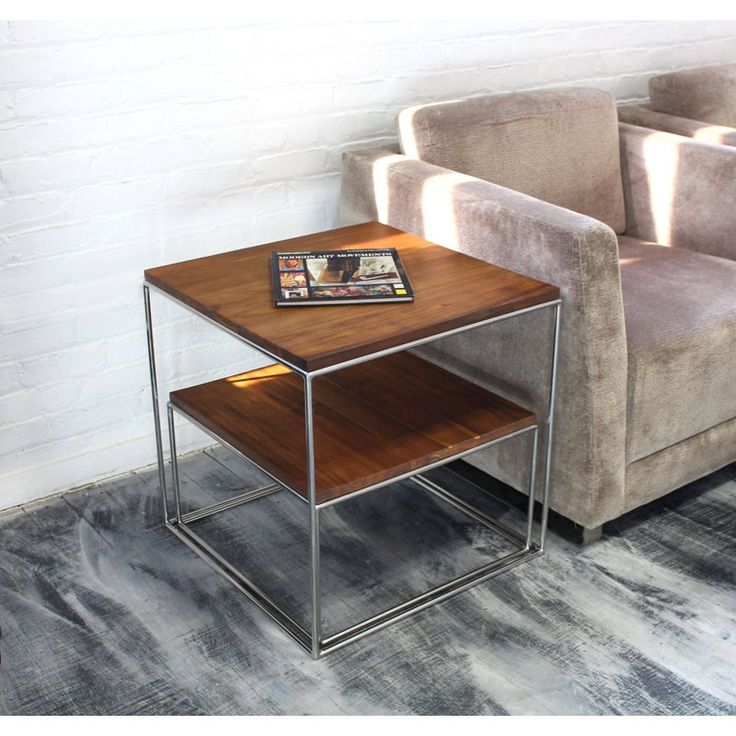 a small wooden table sitting on top of a gray carpeted floor next to a couch