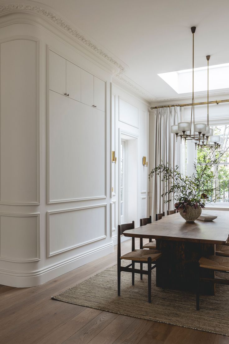 a dining room table with chairs and a potted plant in the center on top of it