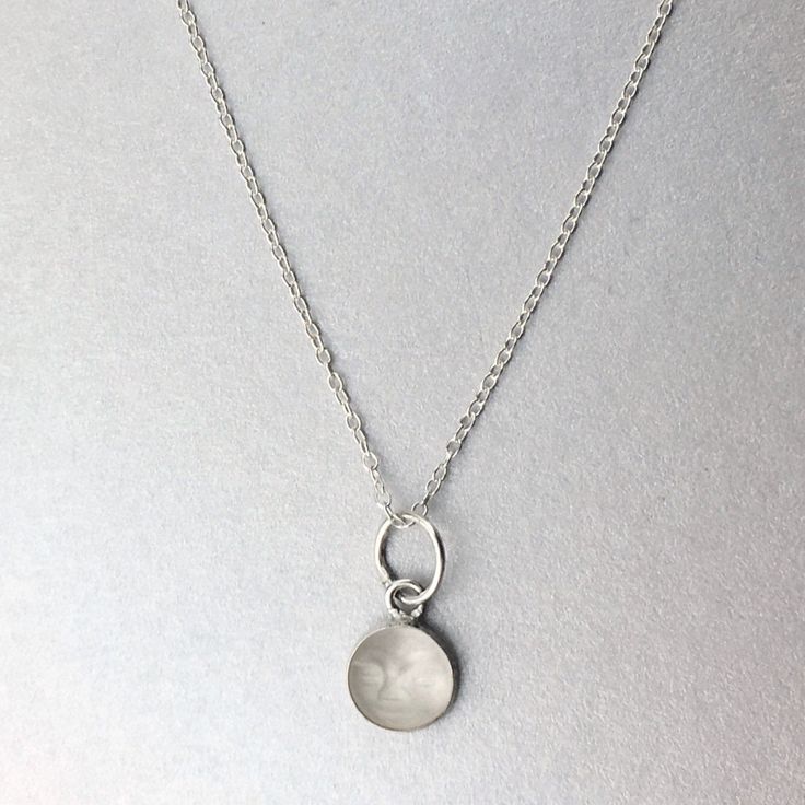 This is a lovely sterling silver pendant featuring a vintage hand carved natural quartz moon face. The quartz crystal is natural quartz and has a matte finish. It was carved in the 1960's. The charm is a perfect size to be worn alone or on a charm necklace or bracelet. The diameter is 8mm, is fully bezel set and the pendant bale is 6mm. If you would like this pendant as a necklace, you can purchase it with a necklace chain: https://www.etsy.com/listing/238444130/necklace-chains-for-pendants Also Silver Dainty Moon Charm Necklace, White Sterling Silver Necklace With Moon Charm, Dainty Silver Necklace With Moon Charm, Minimalist Silver Moon Charm Necklaces, Silver Charm Necklace With Moon Charm As Gift, Spiritual Silver Moon Charm Necklace, Silver Charm Necklace With Moon Charm For Gift, Sterling Silver Moon-shaped Charms Necklaces, Silver Moon Charm Necklace