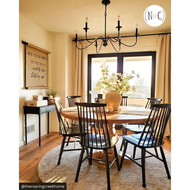 a dining room table with four chairs and a chandelier hanging from the ceiling