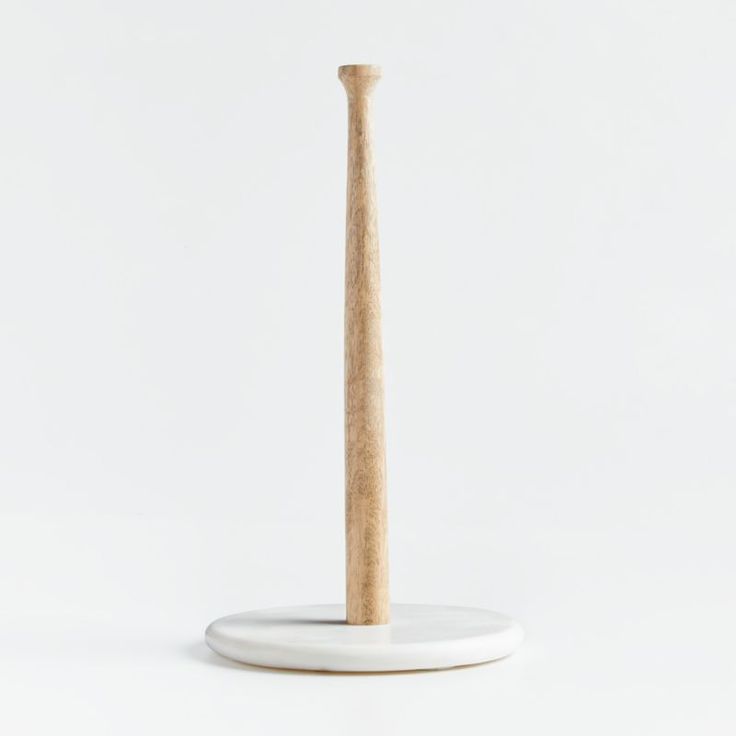 a wooden toothbrush holder on a white surface with a wood stick sticking out of it