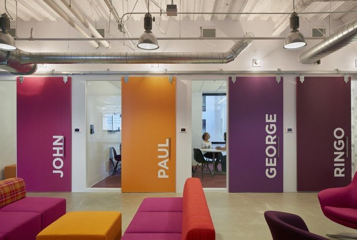 an office with bright colored furniture and large doors