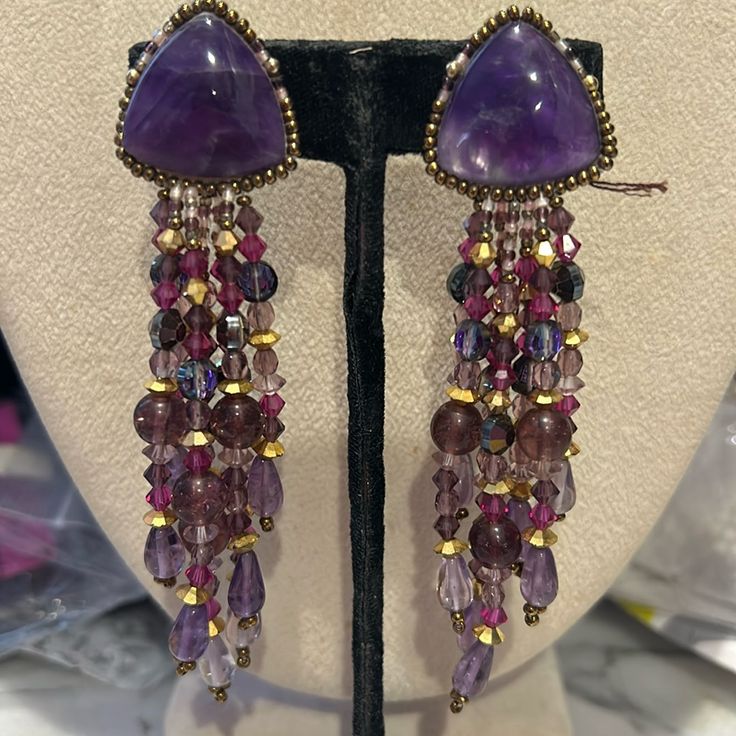 So Gorgeous!!!!! This Is A Pair Of Authentic Chipita Earrings From The 1980s. We Carried The Collection In Our Wearable Art Gallery In Ny And Just Uncovered Several Pieces That Have Been Packed Away After We Moved Locations. These May Be Over 40 Years Old But They Are Brand New. They Are Designer Stamped. This Pair Is Beautiful. It Features Genuine Amethyst Semi Precious Stones And Amethyst Cut Crystals. There Are Gold Crystal Accent Beads. These Are 4” Long And Clip On Style Earrings Signed Sto Elegant Handmade Purple Clip-on Earrings, Purple Dangling Beads Jewelry For Party, Purple Dangling Beads Earrings For Party, Purple Dangling Beads Party Earrings, Handmade Purple Chandelier Earrings For Party, Purple Beaded Earrings For Party, Purple Drop Earrings With Dangling Beads, Handmade Purple Amethyst Chandelier Earrings, Purple Amethyst Earrings With Dangling Beads