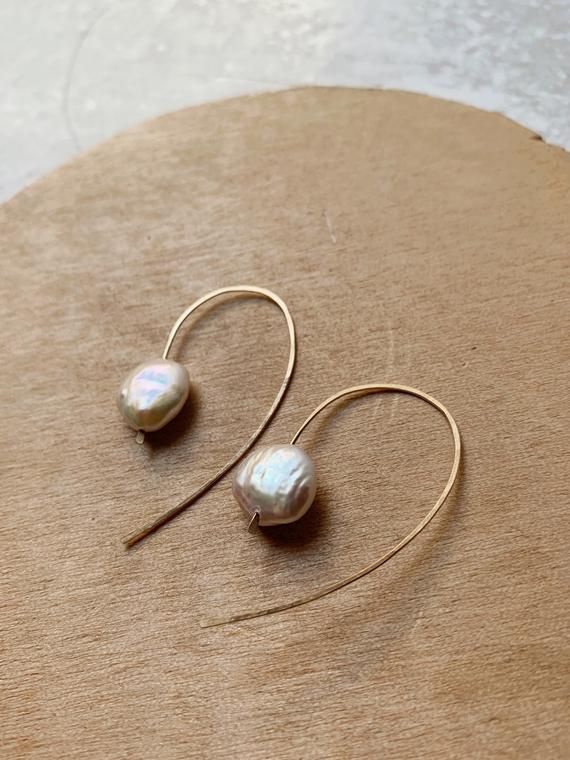 Midi Open hoops in white coin pearls - the perfect middle size between statement and mini hoop! Made from your choice of gold filled, rose gold filled and sterling silver. Shown in gold filledHammered and hand finished with a soft polish Color: a soft bridal white. this listing is for the mini hoops with tiny rice pearls only! Our original Ocean Hoops and Mini pearl hoops are available in separate listings! Small Hoop 14k Gold Filled Pearl Earrings, Adjustable Round Pearl Earrings For Anniversary, Pearl White Round Earrings For Everyday, Hypoallergenic 14k Gold-filled Round Pearl Earrings, 14k Gold-filled Round Pearl Earrings With Charm, Dainty Rose Gold Round Pearl Earrings, Dainty Rose Gold Pearl Earrings, Dainty Round Pearl Earrings With Ear Wire, Minimalist 14k Gold Filled Pearl Earrings For Anniversary