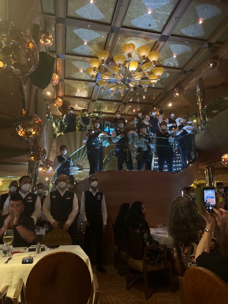 a group of people wearing masks and standing in front of a crowd at a restaurant