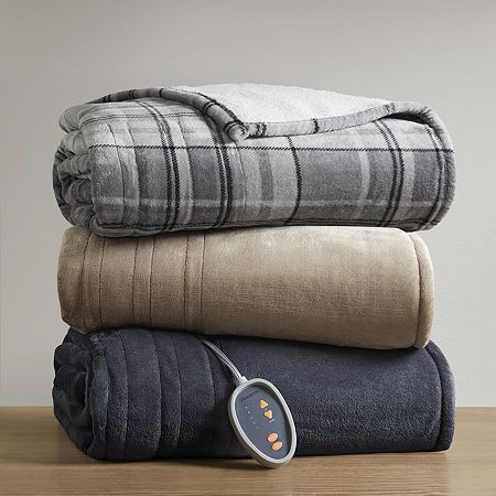 three blankets stacked on top of each other with an electric heater in the middle