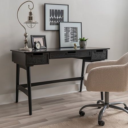 a desk with a chair and pictures on the wall behind it in a room that has hardwood floors