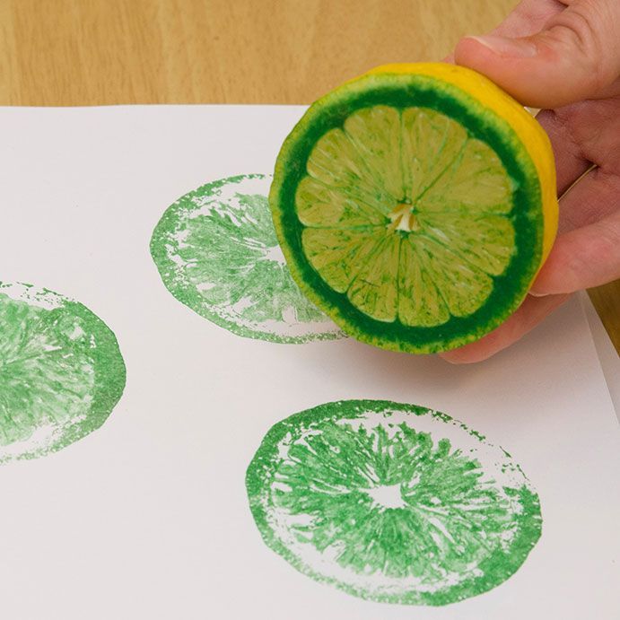 a hand is holding a lemon and stamping on paper