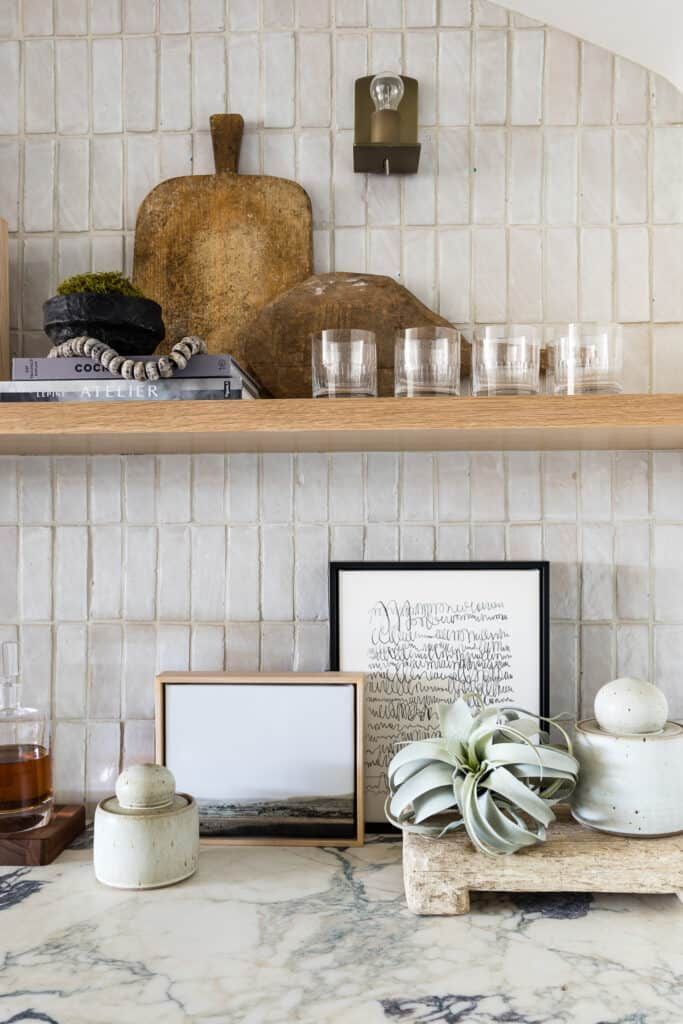 a kitchen counter topped with pots and pans next to a shelf filled with dishes