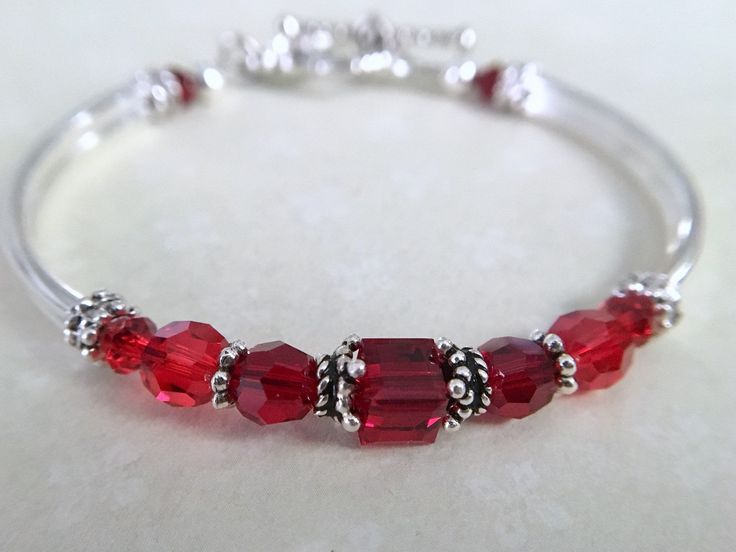 Ruby red bangle bracelet - perfect to gift for your loved ones birthday! Very comfortable and stylish. Message me to change the colors... ~ 6mm garnet swarovski crystal ~ 4mm and 6mm garnet and siam swarovski crystals ~ 6mm sterling silver bead caps ~ silver plated tube bead bangles and toggle Click here to return to my shop's homepage: https://www.etsy.com/shop/beadedjewelryforyou?ref=simple-shop-header-name&listing_id=604235185 Red Sterling Silver Jewelry For Birthday, Adjustable Red Bracelets For Anniversary, Nickel-free Red Jewelry For Birthdays, Personalized Red Beaded Bracelets For Birthday, Adjustable Red Birthstone Bracelet, Red Bracelet For Valentine's Day Birthday, Red Stackable Jewelry For Gifts, Red Stackable Jewelry As Gift, Customizable Red Jewelry For Birthday