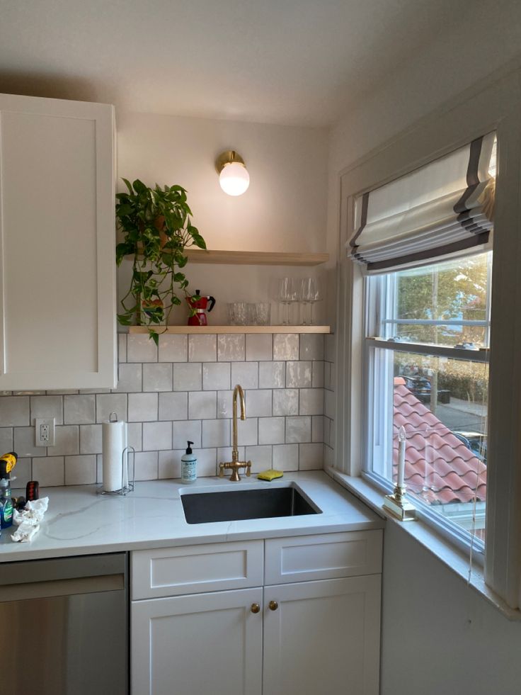 a kitchen with a sink, dishwasher and window in the backround