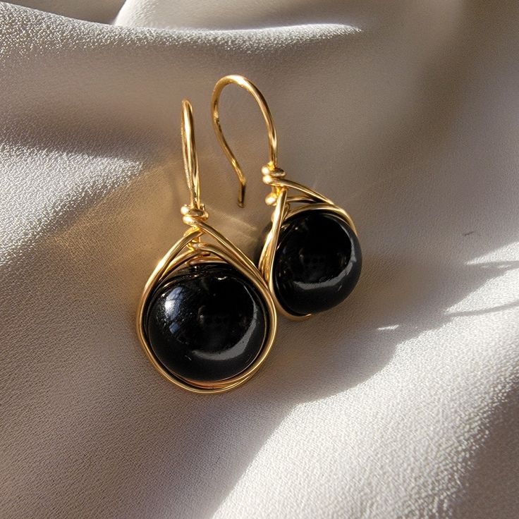 Immerse yourself in spectacular luxury with our Large Black Pearl Earrings in a drop design. These magnificent jewels fuse the timeless elegance of pearls with a touch of contemporary boldness, offering a stunning visual impact. Each majestically selected black pearl hangs gracefully in a generous drop design, providing unmatched visual appeal. The fullness of these black pearls adds a touch of drama and sophistication to your style, turning your every move into a fashion statement. The meticulously crafted setting, available in gold fill enhances the natural beauty of the pearls and adds a touch of opulence to these earrings. These jewels are not only accessories, but masterpieces that will transform any occasion into an elegant event. Whether for a special evening or to elevate your ever Black Pearl Jewelry Design, Luxury Black Pearl Earrings For Anniversary, Elegant Teardrop Earrings Gift, Elegant Round Wire Wrapped Jewelry, Elegant Wire Wrapped Jewelry For Parties, Teardrop Earrings For Evening With Ear Wire, Evening Teardrop Earrings With Ear Wire, Wire Wrapped Drop Jewelry For Party, Party Wire Wrapped Drop Earrings