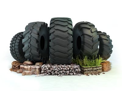 four large tires sitting on top of each other in front of rocks and grass next to stones