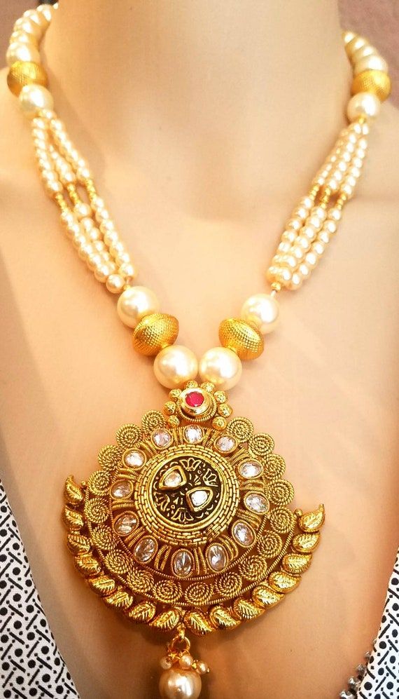 Check out this item in my Etsy shop https://www.etsy.com/listing/715776379/gold-necklace-indian-jewelry-indian Gold Chandbali Pearl Necklace In Temple Jewelry Style, Gold Chandbali Pearl Necklace In Temple Style, Traditional Gold Plated Chandbali Bridal Necklace, 22k Gold Bridal Necklace With Latkans, Gold Kundan Pearl Pendant Necklace, Gold Chandbali Pearl Necklace For Puja, Gold Plated Temple Jewelry Bridal Necklace For Diwali, Heavy Gold Plated Kundan Necklace For Festivals, Diwali Temple Jewelry Bridal Necklace In Gold Plated