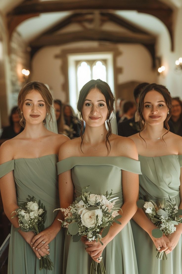 four bridesmaids in green dresses stand together at the end of their wedding ceremony